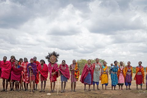 SVM_7705 
Maasai villagers in traditional  colourful   warrior outfit; red shuka cloth beaded necklaces, an iron rod (as a weapon) performing